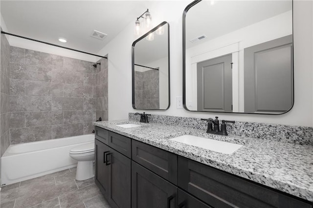 full bathroom featuring vanity, tiled shower / bath combo, and toilet