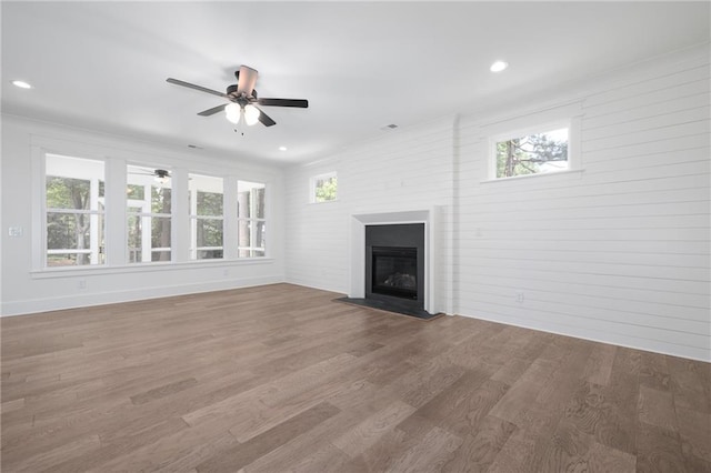 unfurnished living room with hardwood / wood-style flooring, a healthy amount of sunlight, and ceiling fan