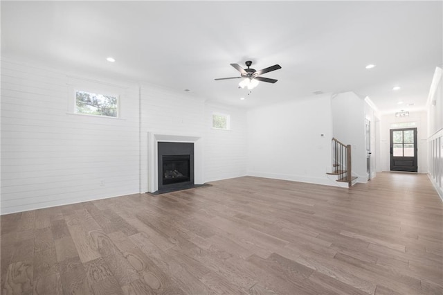 unfurnished living room featuring ceiling fan and light wood-type flooring