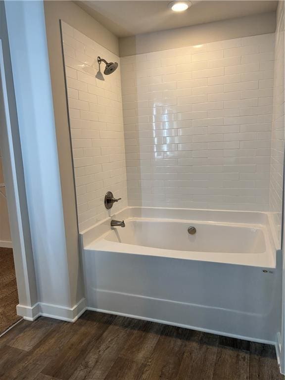 full bath featuring bathing tub / shower combination, baseboards, and wood finished floors