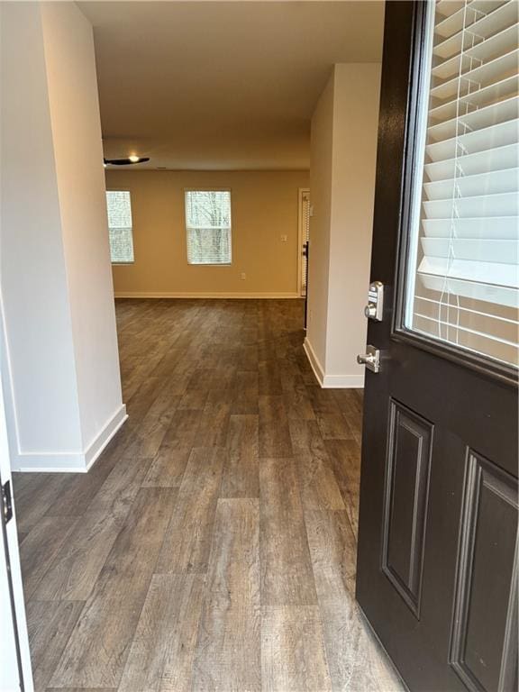 interior space featuring baseboards and dark wood-type flooring