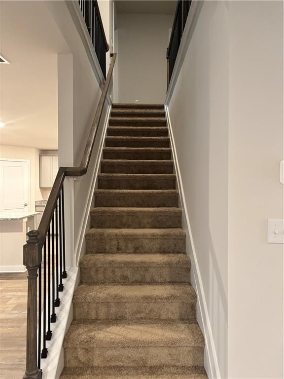 stairway featuring baseboards and wood finished floors