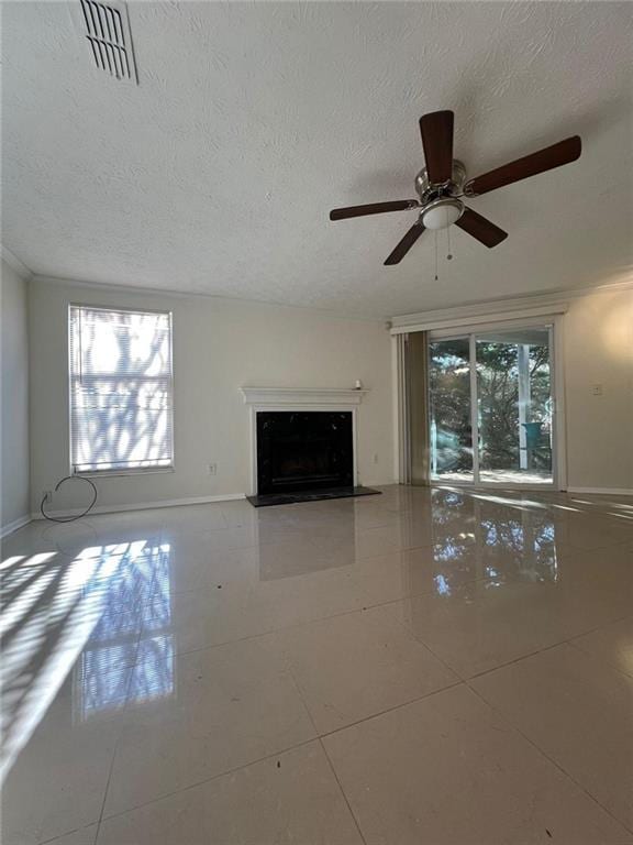 unfurnished living room featuring ceiling fan, tile patterned flooring, and a textured ceiling