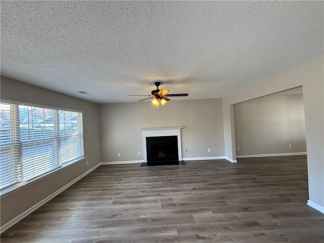 unfurnished living room with ceiling fan, wood-type flooring, and a textured ceiling