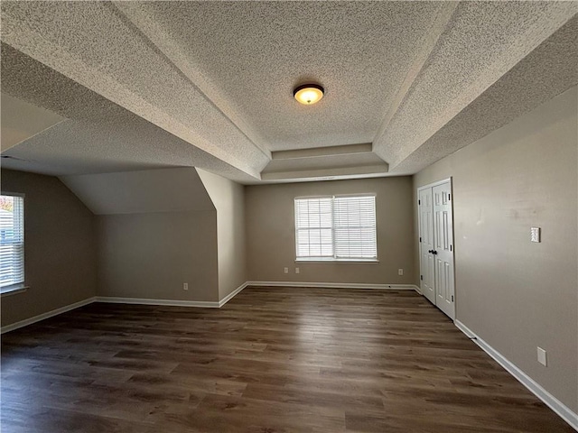 bonus room featuring lofted ceiling, dark wood-type flooring, and a textured ceiling