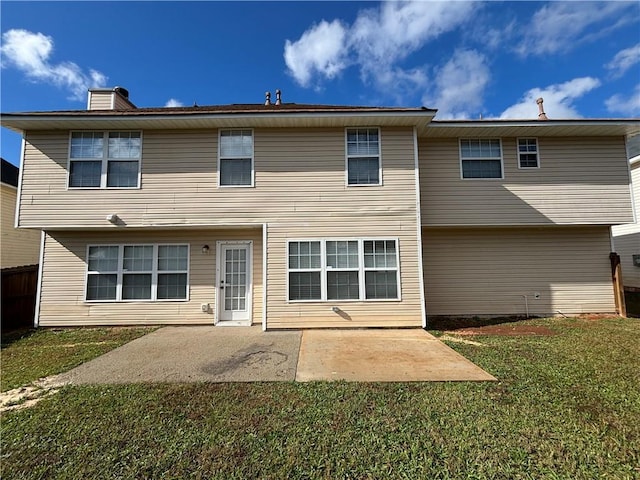 rear view of property featuring a lawn and a patio area