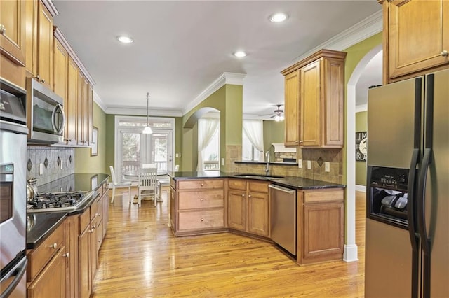 1605 Pavillion Ridge Dr SE, Smyrna, GA 30080 - kitchen with appliances with stainless steel finishes, arched walkways, light wood-style flooring, ornamental molding, and tasteful backsplash