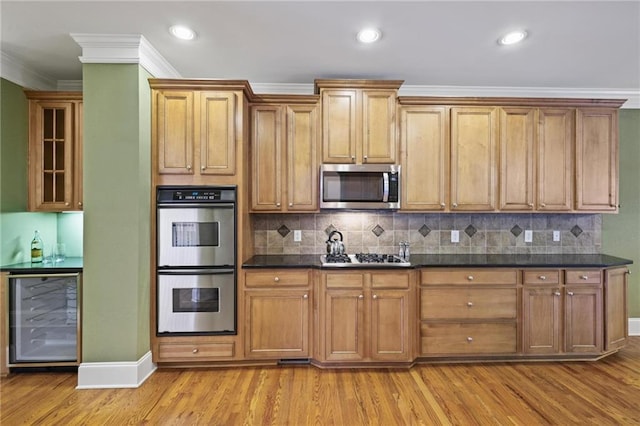 1605 Pavillion Ridge Dr SE, Smyrna, GA 30080 - kitchen with stainless steel appliances, wine cooler, light wood-type flooring, dark countertops, and crown molding