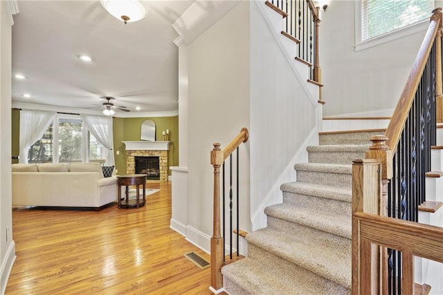 1605 Pavillion Ridge Dr SE, Smyrna, GA 30080 - staircase featuring ceiling fan, wood finished floors, a fireplace, recessed lighting, and crown molding