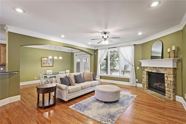 1605 Pavillion Ridge Dr SE, Smyrna, GA 30080 - living area with crown molding, arched walkways, a fireplace, ceiling fan, and wood finished floors