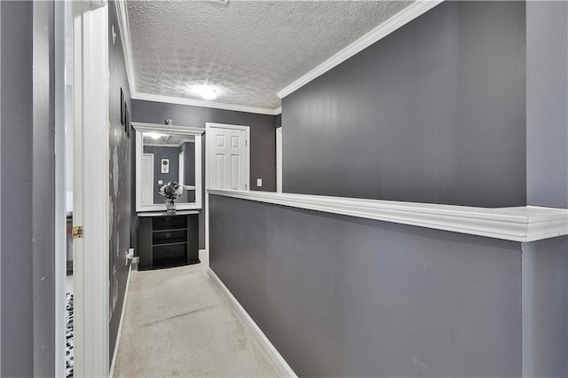 hallway featuring ornamental molding, light colored carpet, and a textured ceiling