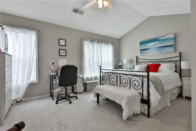 bedroom with light carpet, a textured ceiling, vaulted ceiling, and ceiling fan