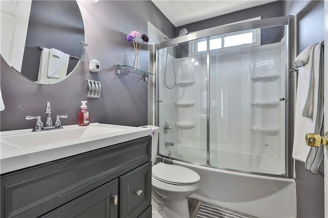 full bathroom with vanity, toilet, combined bath / shower with glass door, and a textured ceiling