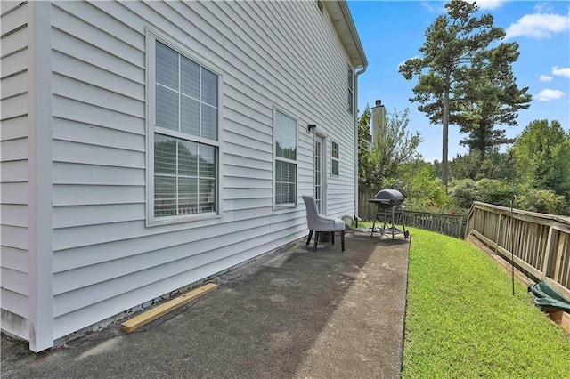 view of side of property featuring a yard and a patio