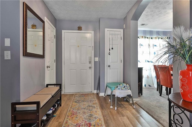 entrance foyer featuring a textured ceiling and light wood-type flooring