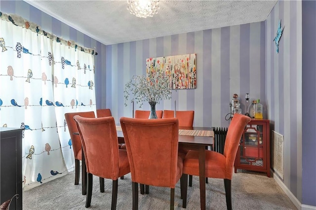 dining area featuring carpet and a textured ceiling