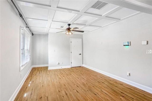 unfurnished room with ceiling fan, coffered ceiling, beam ceiling, and light hardwood / wood-style flooring