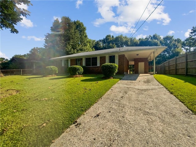 single story home featuring brick siding, fence, driveway, a carport, and a front yard