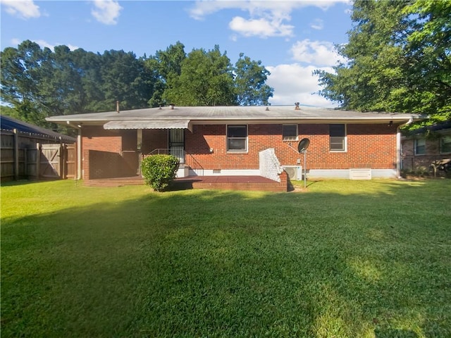 back of house with crawl space, a yard, and brick siding