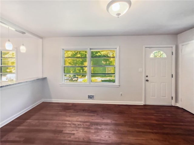 entrance foyer with dark wood-style flooring, visible vents, and baseboards