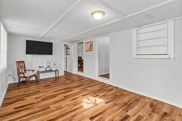 sitting room featuring hardwood / wood-style floors and built in shelves