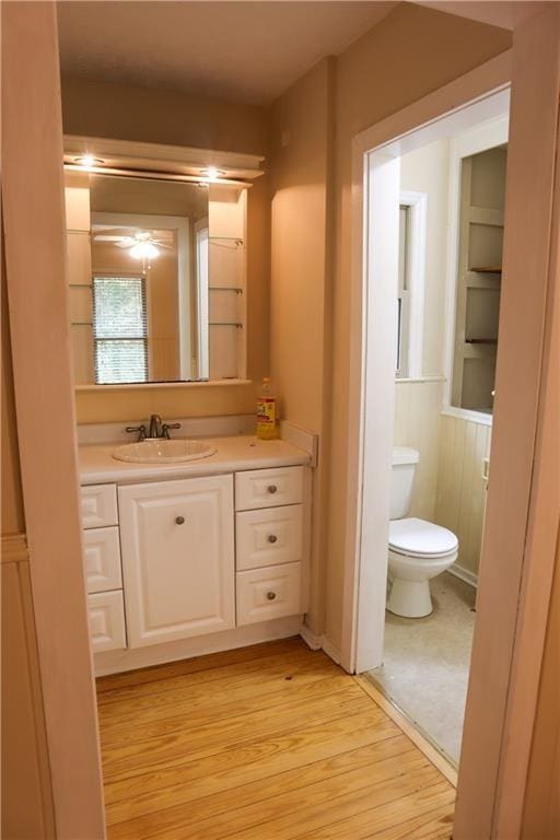 bathroom featuring toilet, wood finished floors, and vanity