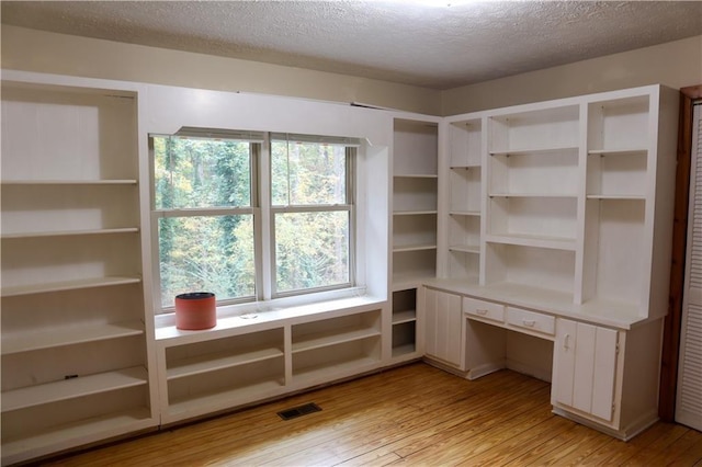unfurnished office with a textured ceiling and light wood-style flooring
