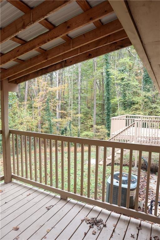 deck featuring central AC unit and a forest view