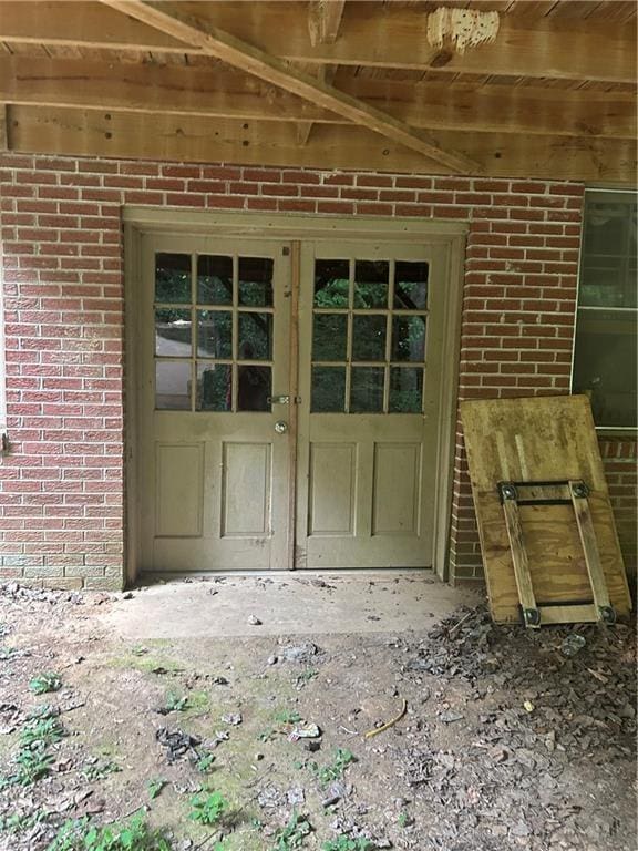 view of exterior entry featuring brick siding