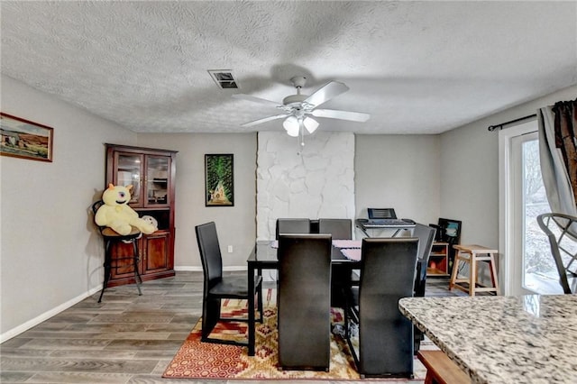 dining area with ceiling fan, a textured ceiling, and dark hardwood / wood-style flooring