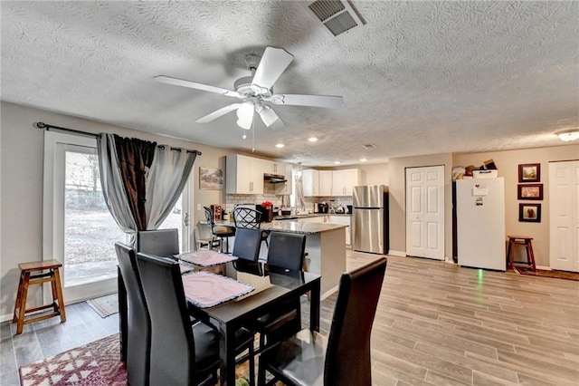 dining room featuring light hardwood / wood-style floors and ceiling fan