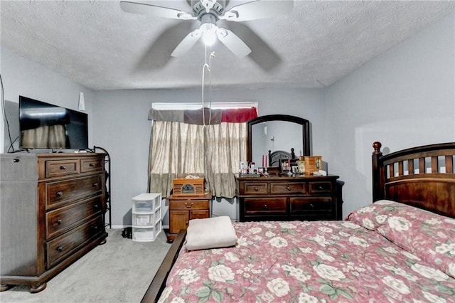 bedroom with ceiling fan, carpet floors, and a textured ceiling