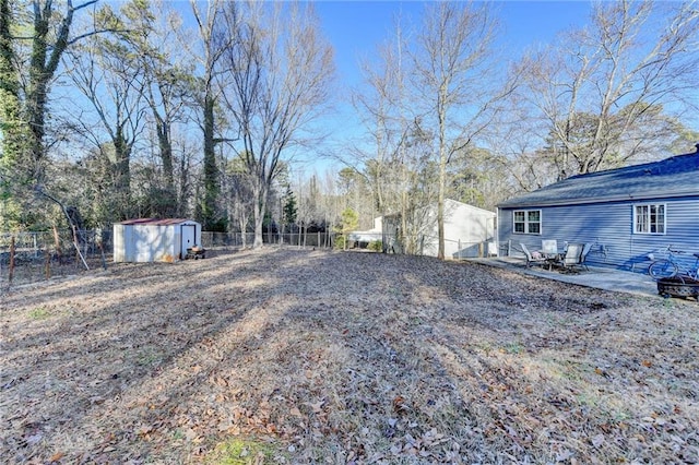 view of yard with a storage shed, a fire pit, and a patio