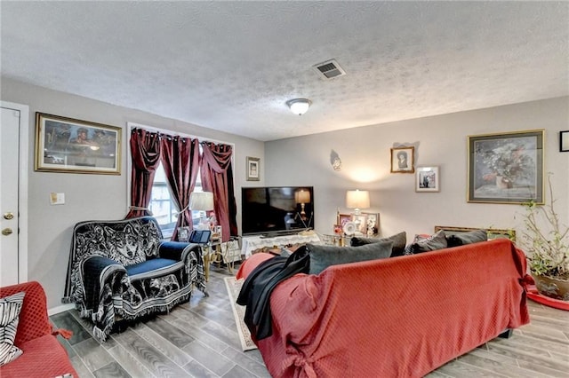 living room with hardwood / wood-style floors and a textured ceiling