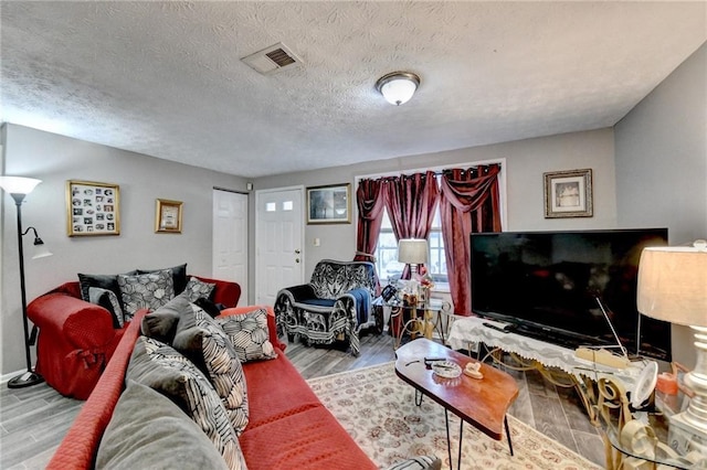 living room with wood-type flooring and a textured ceiling