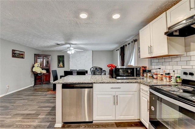 kitchen with tasteful backsplash, light wood-type flooring, kitchen peninsula, stainless steel appliances, and white cabinets