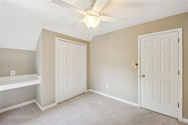 unfurnished bedroom with carpet floors, baseboards, a closet, and ceiling fan