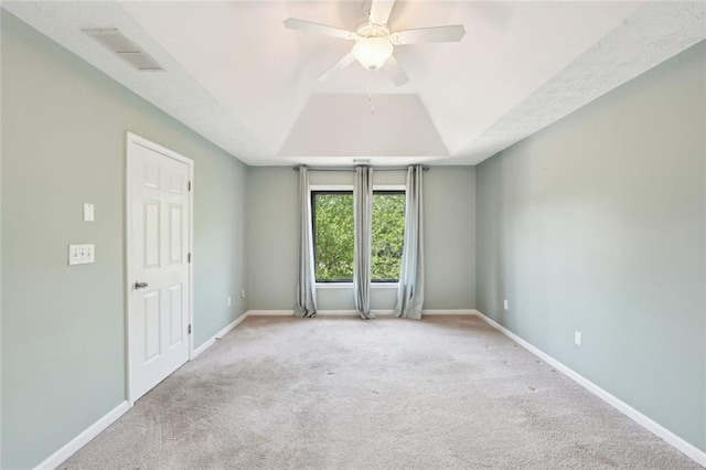 unfurnished room featuring visible vents, baseboards, ceiling fan, a raised ceiling, and carpet flooring