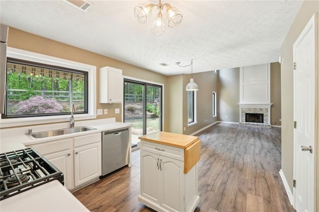 kitchen with visible vents, a sink, a textured ceiling, and dishwasher