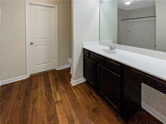 bathroom with wood-type flooring, vanity, and toilet