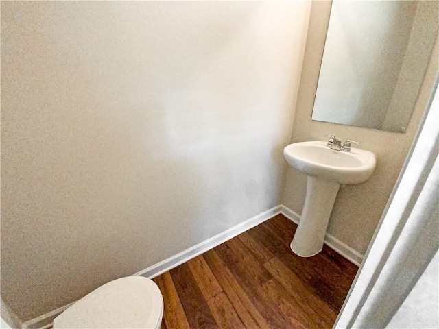 bathroom with toilet and hardwood / wood-style flooring