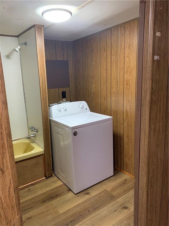 clothes washing area with light wood-type flooring and washer / clothes dryer