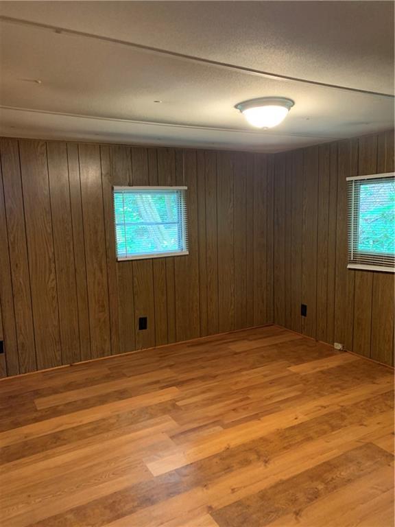 spare room featuring light wood-type flooring and wooden walls