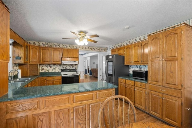 kitchen featuring ceiling fan, a sink, brown cabinets, and appliances with stainless steel finishes