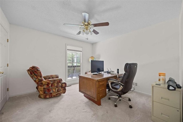 office area with baseboards, a textured ceiling, a ceiling fan, and light colored carpet