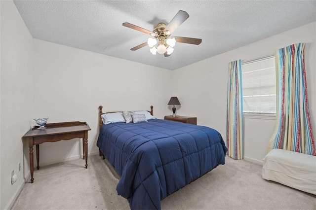 bedroom with light colored carpet, baseboards, and a textured ceiling