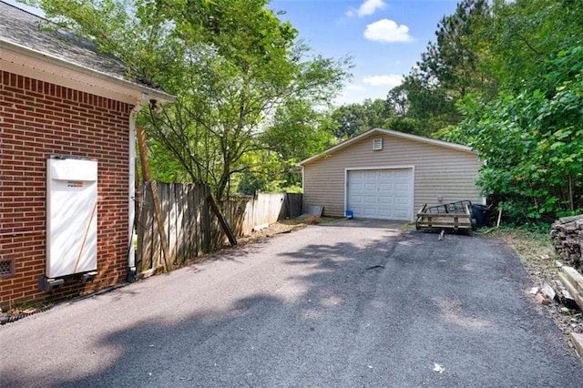 detached garage with fence and aphalt driveway