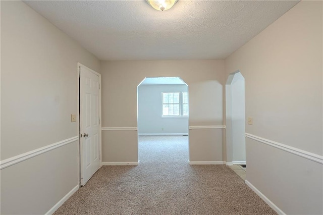 2247 Cherokee Valley Dr, Lithonia, GA 30058 - hallway with arched walkways, a textured ceiling, and carpet flooring