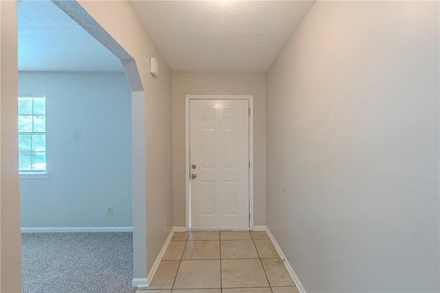 2247 Cherokee Valley Dr, Lithonia, GA 30058 - hallway featuring a textured ceiling, light tile patterned flooring, and arched walkways
