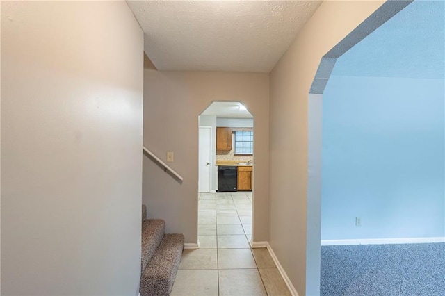 2247 Cherokee Valley Dr, Lithonia, GA 30058 - hall with arched walkways, light tile patterned flooring, stairway, and a textured ceiling